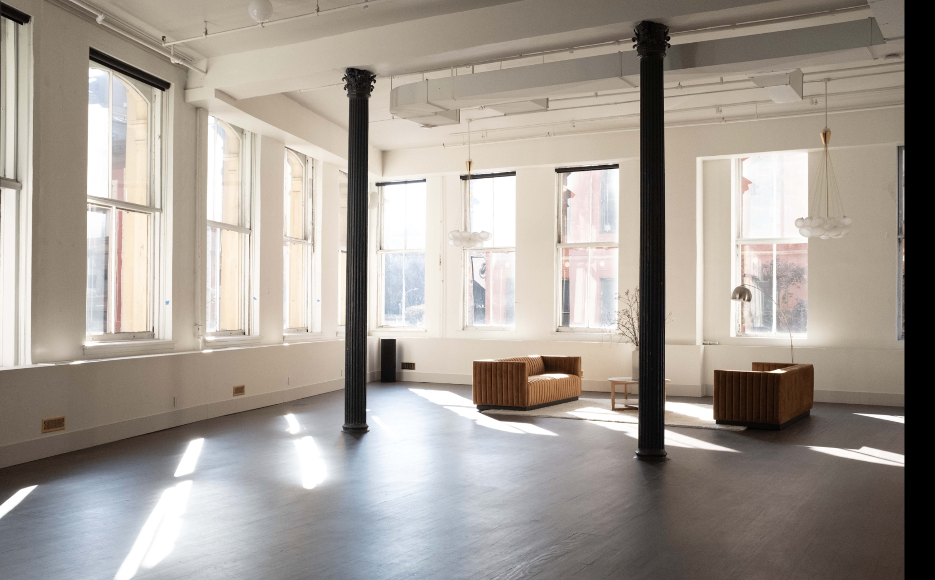 Venue workspace with large windows, elegant columns, and minimal furniture